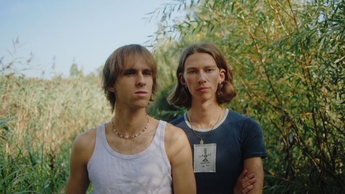 Joscha und Finn stehen in T-Shirt in einer grünen Landschaft | Quelle: Feellikeweusedto