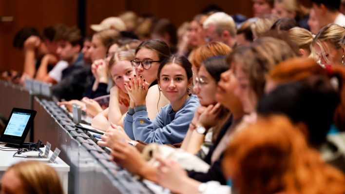 Studis bei einer Uni-Einführungsveranstaltung (Quelle: IMAGO | Panama Pictures)