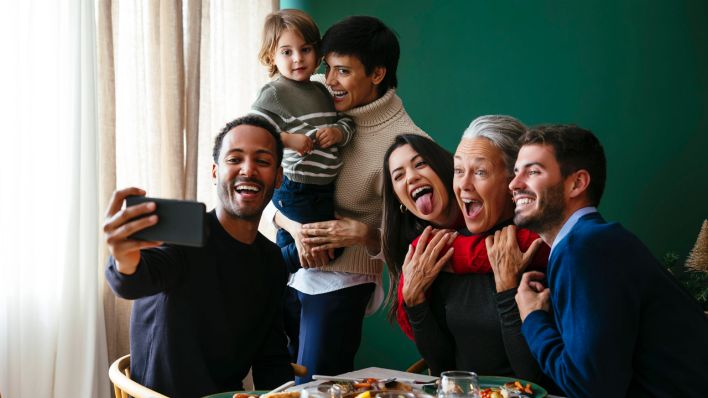 Familie macht an Weihnachten ein Selfie von sich. (Quelle: IMAGO | Westend61)